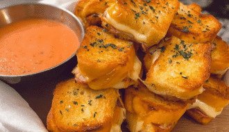Golden Hawaiian roll mini grilled cheese sandwiches stacked with gooey melted cheese, served with tomato soup dip.