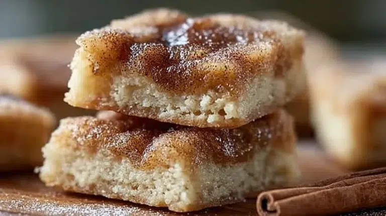 Freshly baked cinnamon sugar blondies topped with a sprinkle of cinnamon.