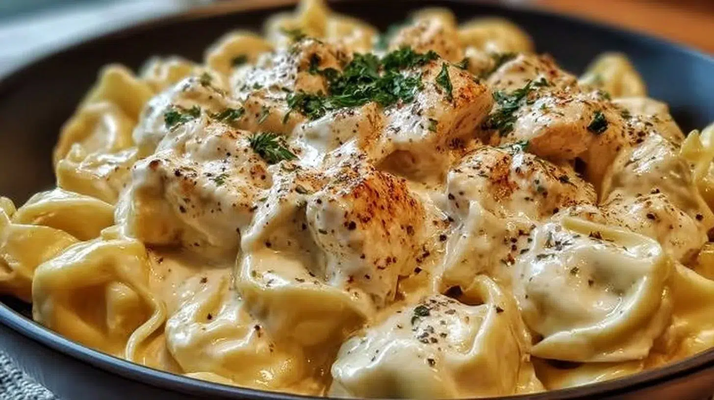 Crockpot Chicken Alfredo Tortellini dish served in a bowl with parsley garnish