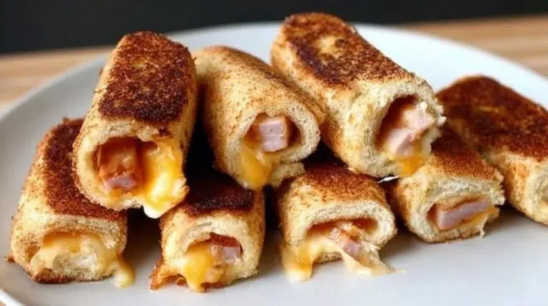 Grilled cheese roll-ups on a plate, golden and melty, perfect for snacks.