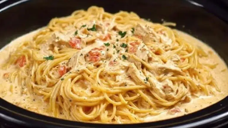 Crock Pot Cheesy Chicken Spaghetti served in a bowl with melted cheese on top.