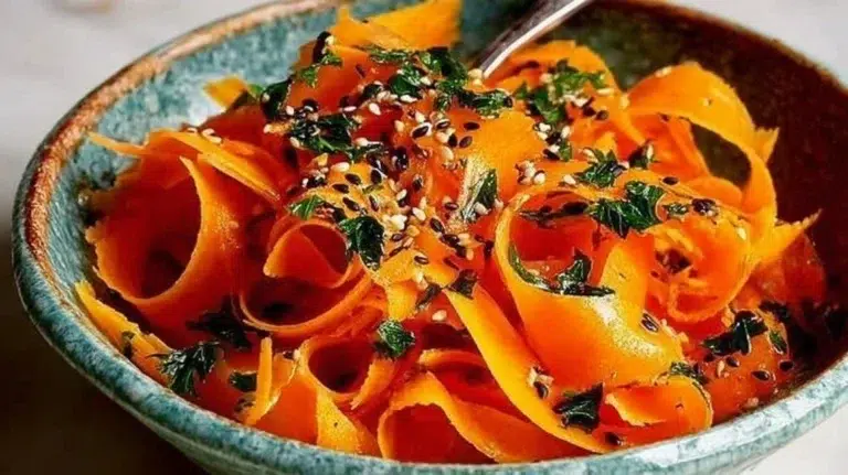 Delicious raw carrot salad served in a bowl with fresh herbs and dressing