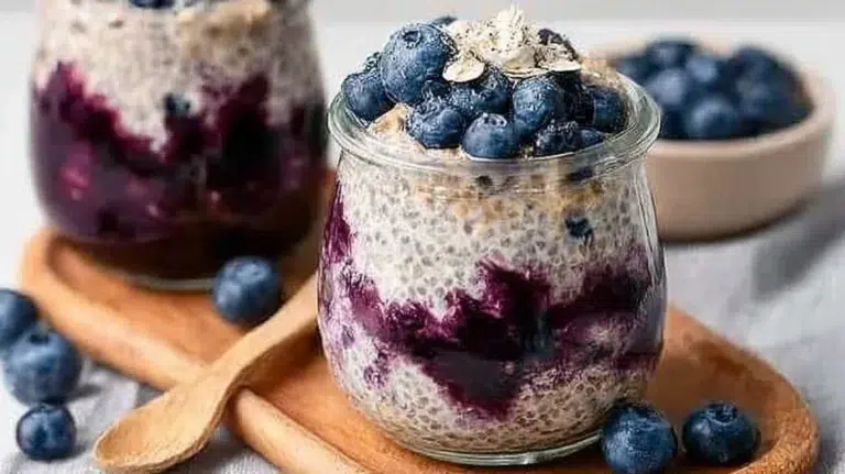 Delicious blueberry overnight oats in a glass jar topped with fresh berries