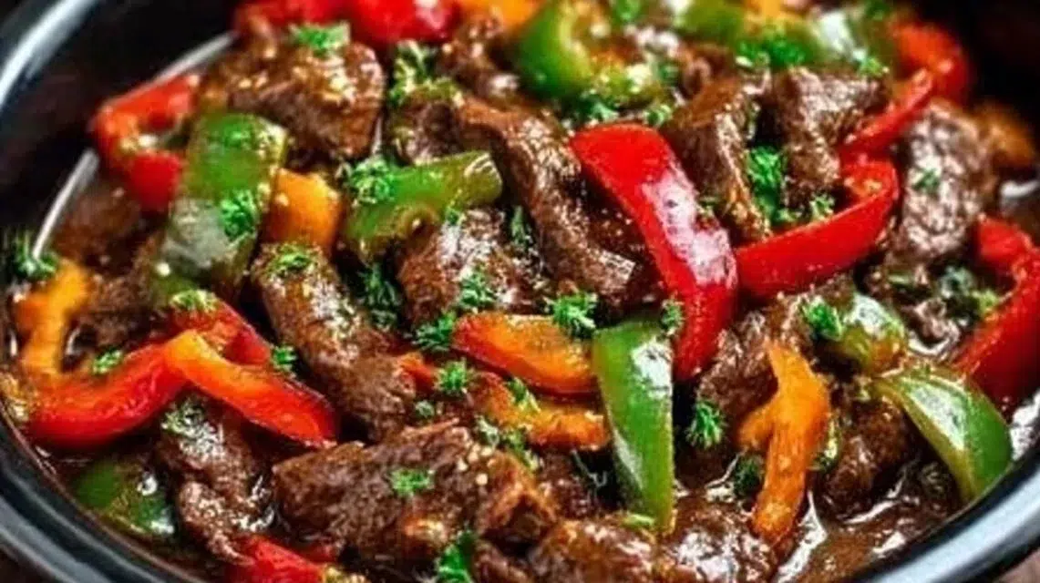 A delicious serving of Crockpot Pepper Steak with bell peppers and sauce.