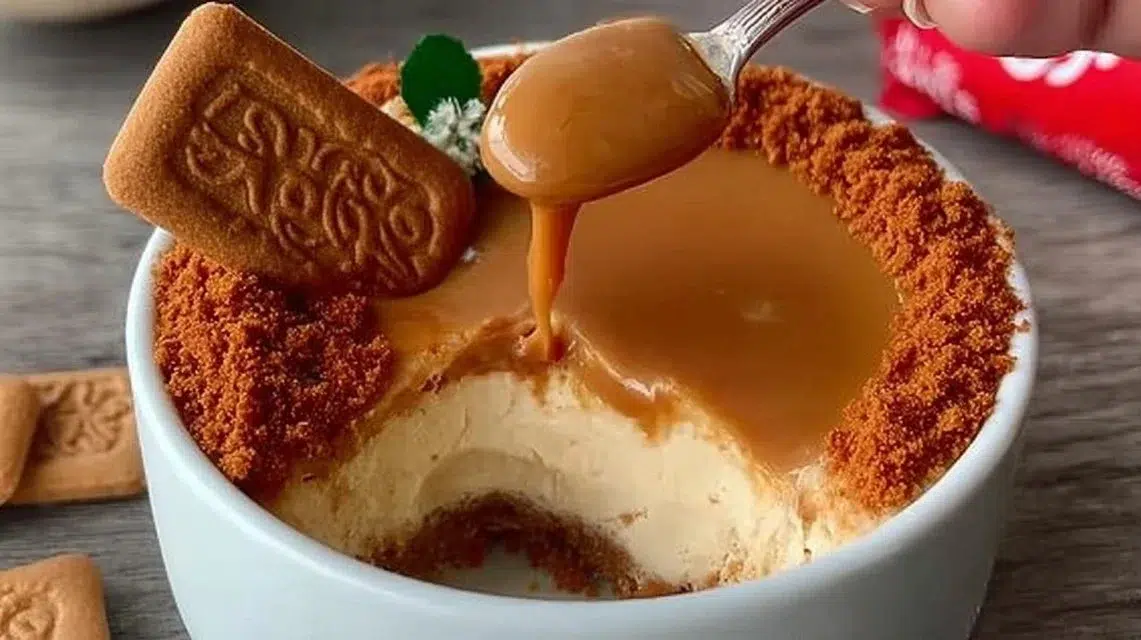 Slice of Lotus Biscoff cheesecake topped with caramel and Biscoff crumbles