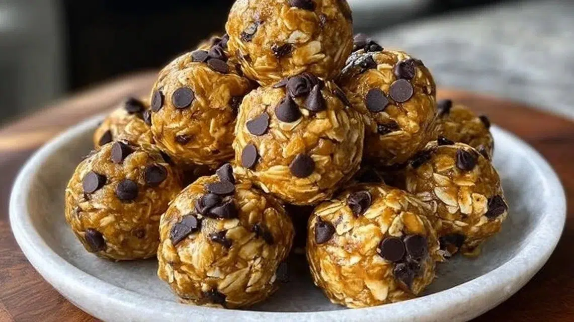 No-bake peanut butter energy bites on a plate with a sprinkle of oats.