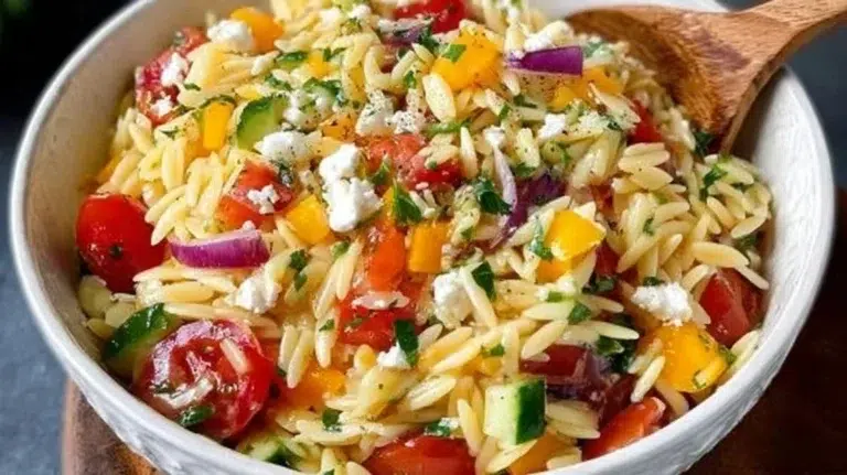 Colorful orzo salad with fresh vegetables and herbs served in a bowl