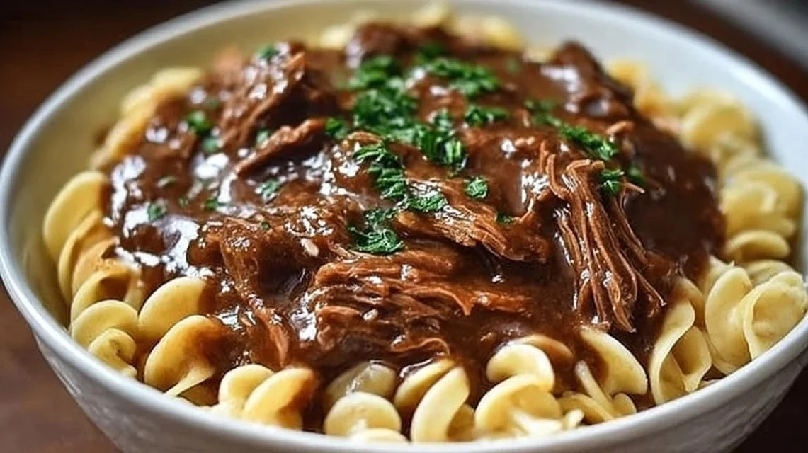 Delicious slow cooker beef noodles in a rich broth with fresh herbs.