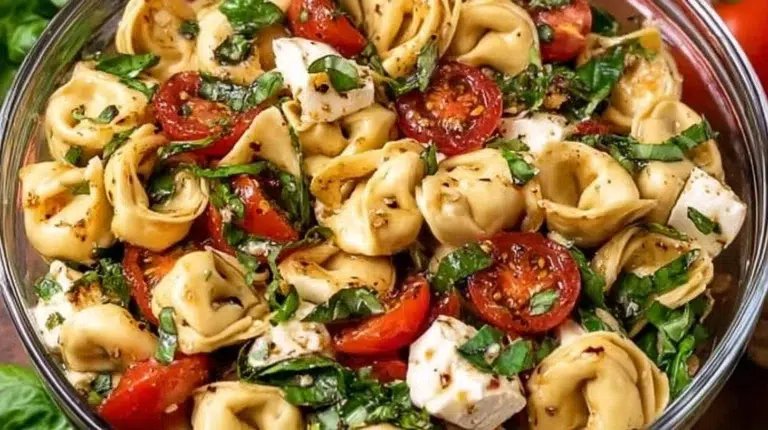 Caprese Tortellini Salad with fresh basil and tomatoes in a bowl