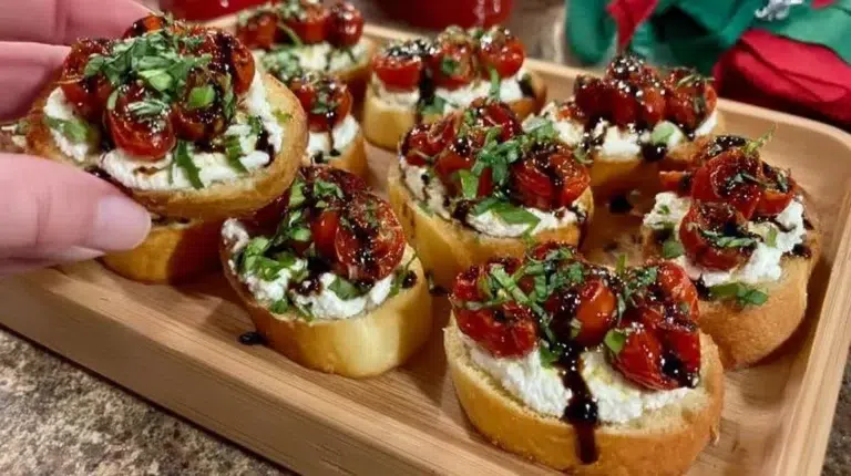 Creamy ricotta crostini with roasted tomatoes and basil on a plate