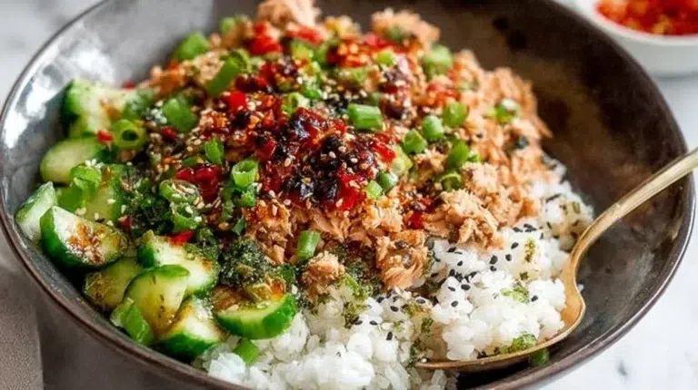 Spicy canned salmon rice bowl with sesame sauce, garnished with veggies.