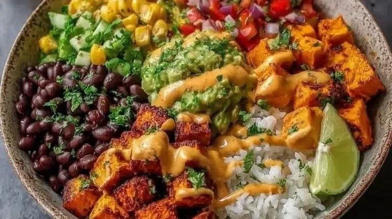 Vegan sweet potato burrito bowl with colorful toppings and fresh ingredients